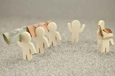 Kleine Figuren mit Geldscheinen und Münzen